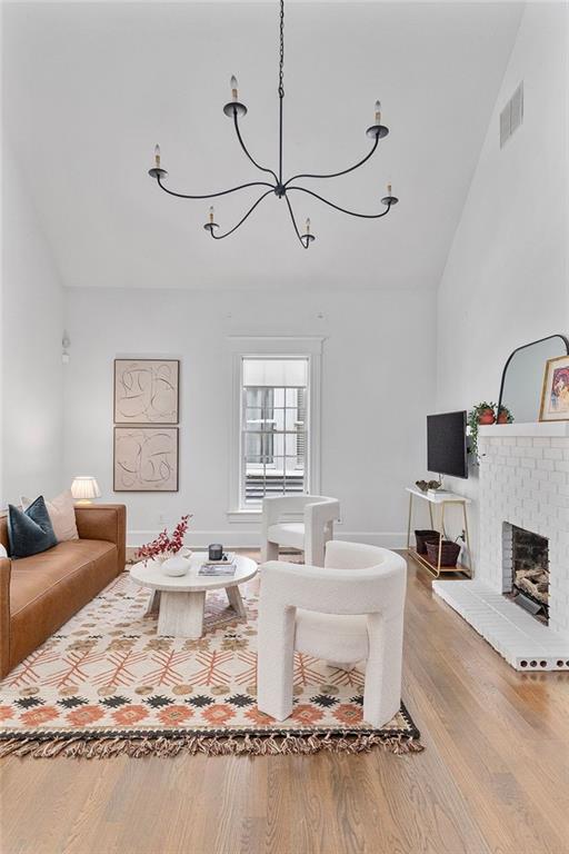 343 Josephine St NE, Atlanta, GA 30307 - living area with wood finished floors, lofted ceiling, a chandelier, and a fireplace
