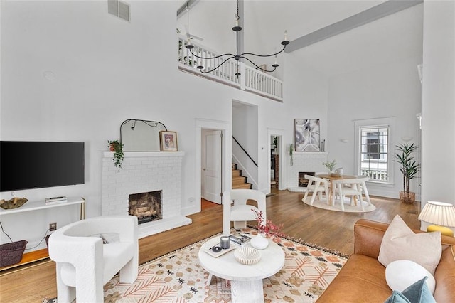 343 Josephine St NE, Atlanta, GA 30307 - living room featuring a towering ceiling, a brick fireplace, wood finished floors, and stairway