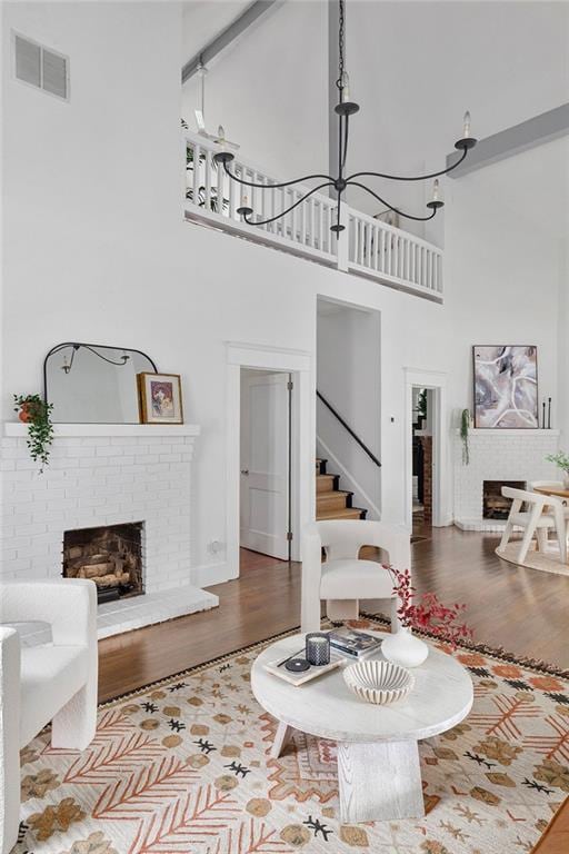 343 Josephine St NE, Atlanta, GA 30307 - living room featuring a high ceiling, a fireplace, wood finished floors, stairs, and a chandelier