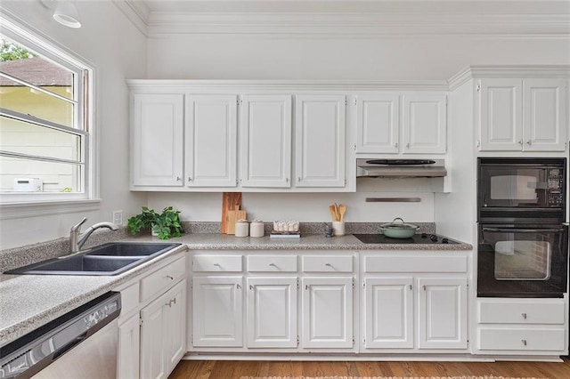 343 Josephine St NE, Atlanta, GA 30307 - kitchen with black appliances, under cabinet range hood, white cabinetry, ornamental molding, and light countertops