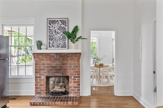 343 Josephine St NE, Atlanta, GA 30307 - living room with wood finished floors, a brick fireplace, and crown molding