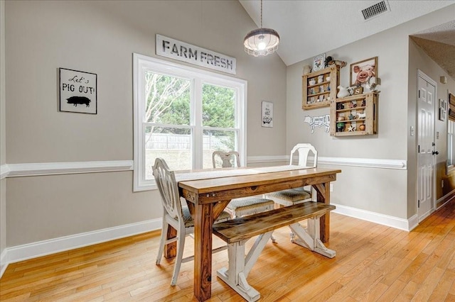 dining space featuring lofted ceiling and wood-type flooring