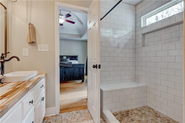 bathroom with vanity, ceiling fan, and tiled shower