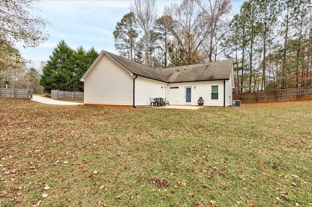 rear view of house featuring a yard, a patio, and central air condition unit