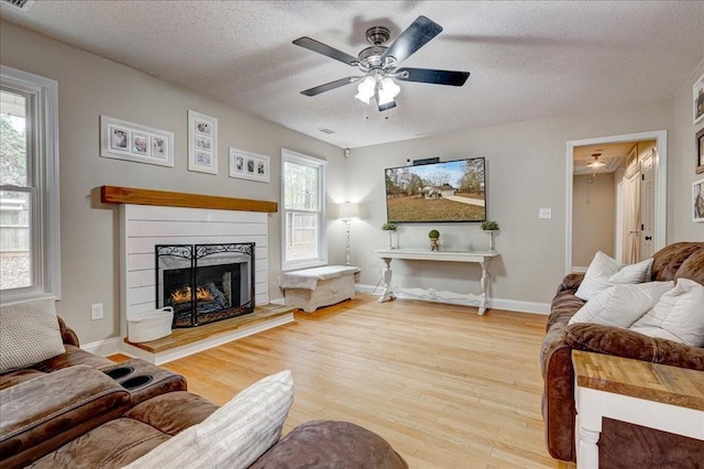 living room with wood-type flooring, a wealth of natural light, and a textured ceiling