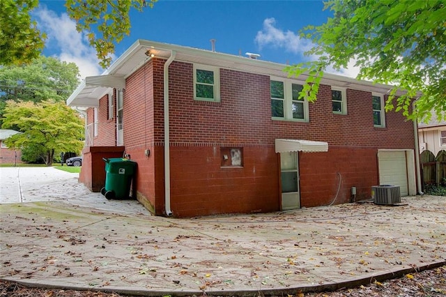 back of property with cooling unit and a garage