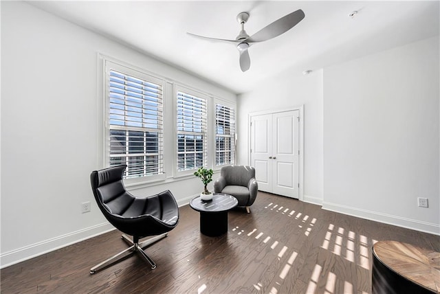 living area featuring ceiling fan and dark wood-type flooring