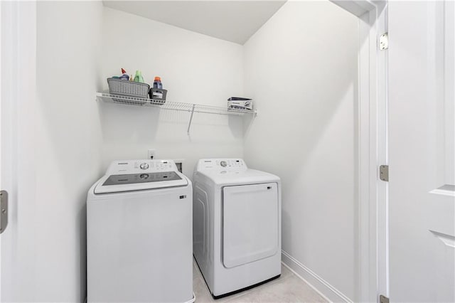 laundry room featuring separate washer and dryer and light tile patterned flooring