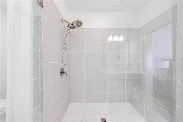 bathroom featuring toilet and a tile shower