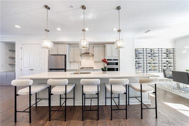 kitchen with pendant lighting, a kitchen breakfast bar, dark hardwood / wood-style flooring, and appliances with stainless steel finishes