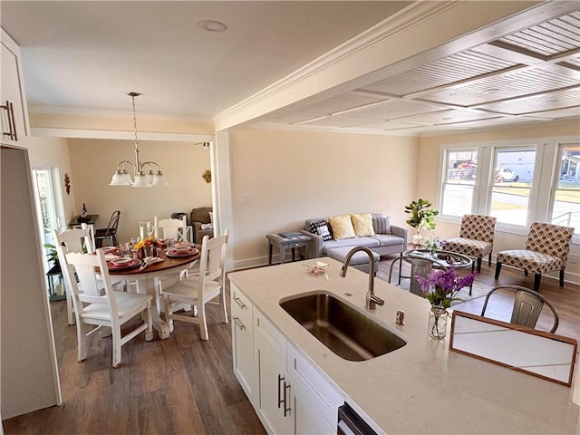 kitchen featuring sink, white cabinets, a chandelier, dark hardwood / wood-style flooring, and hanging light fixtures