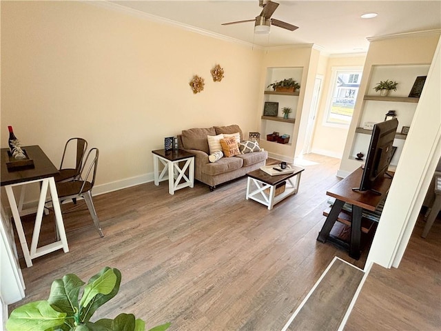 living room featuring hardwood / wood-style floors, ornamental molding, and ceiling fan