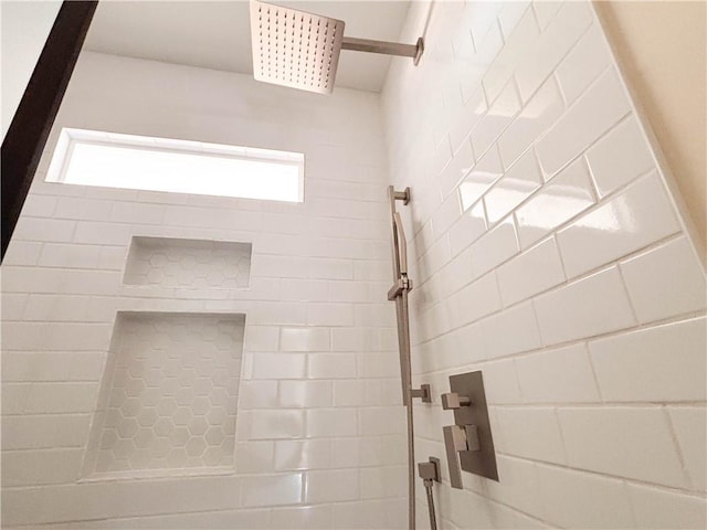 bathroom with tiled shower and a wealth of natural light