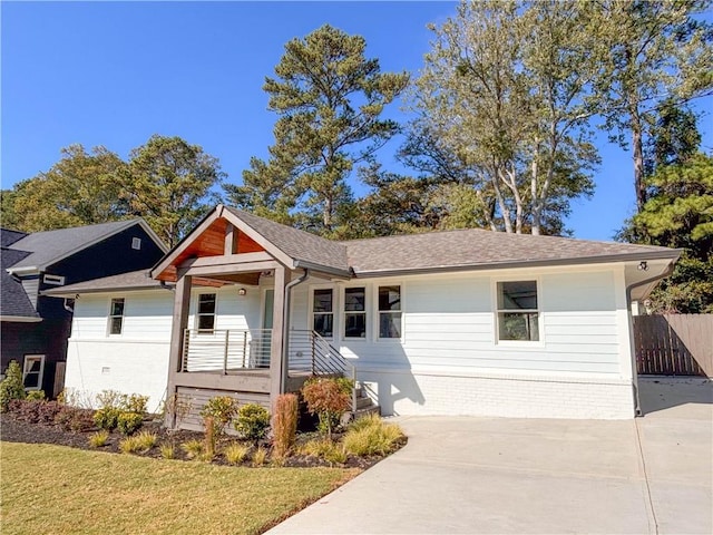 ranch-style house with covered porch and a front yard