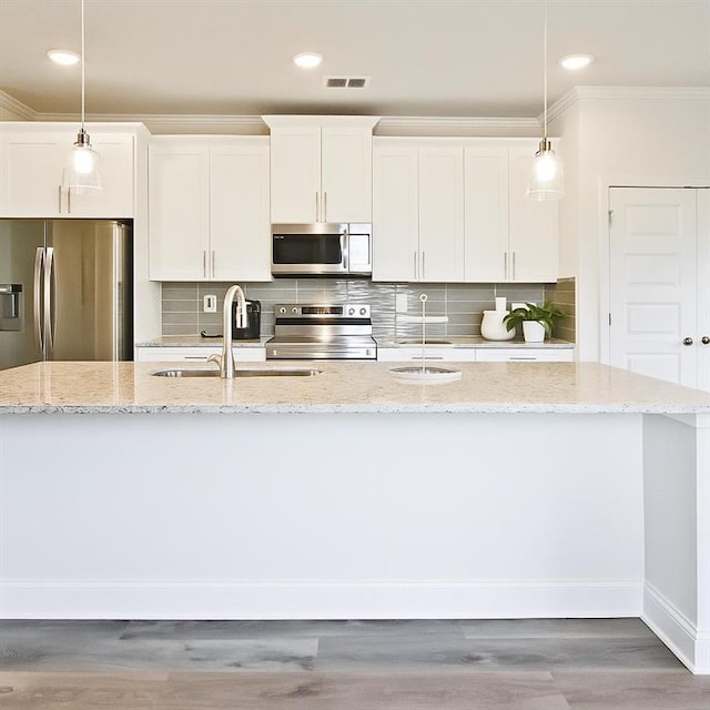 541 Fundao Ln, Lawrenceville, GA 30046 - kitchen featuring stainless steel appliances, ornamental molding, a kitchen island with sink, white cabinets, and decorative backsplash
