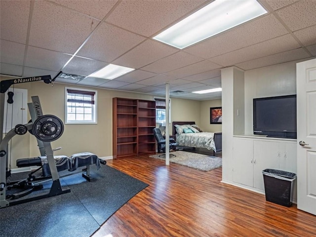 workout room featuring a drop ceiling and wood finished floors