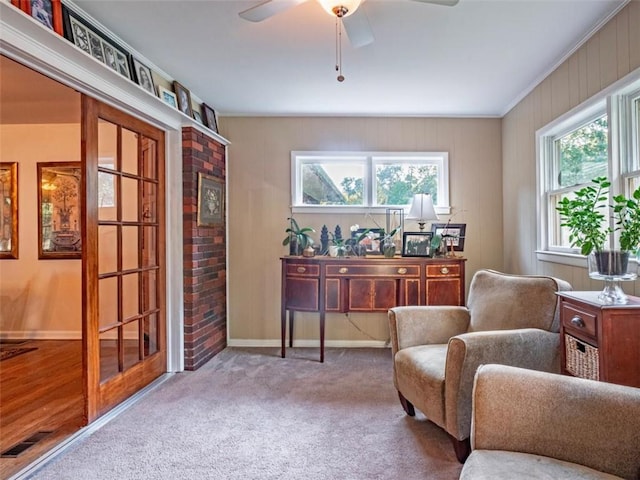 living area featuring baseboards, visible vents, ceiling fan, and carpet flooring