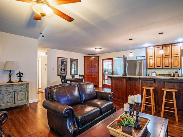 living area featuring dark wood-style flooring and ceiling fan