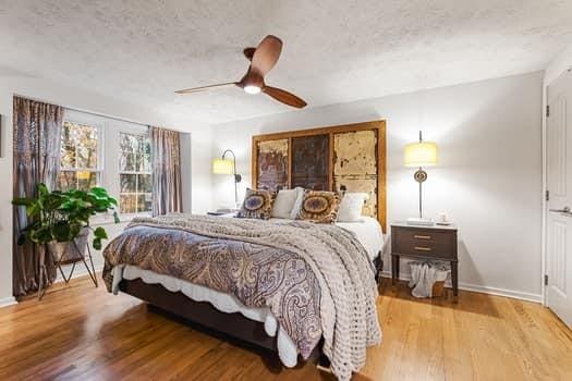 bedroom featuring ceiling fan, wood-type flooring, and a textured ceiling