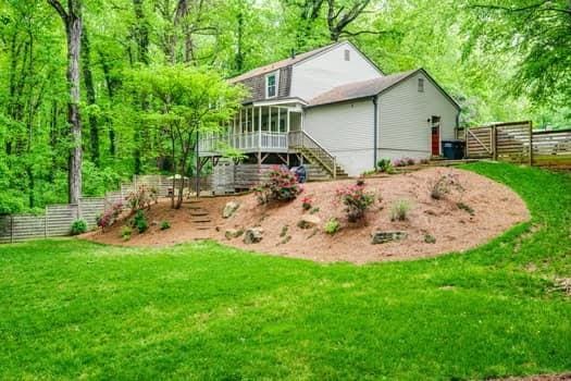 rear view of property with a sunroom and a lawn