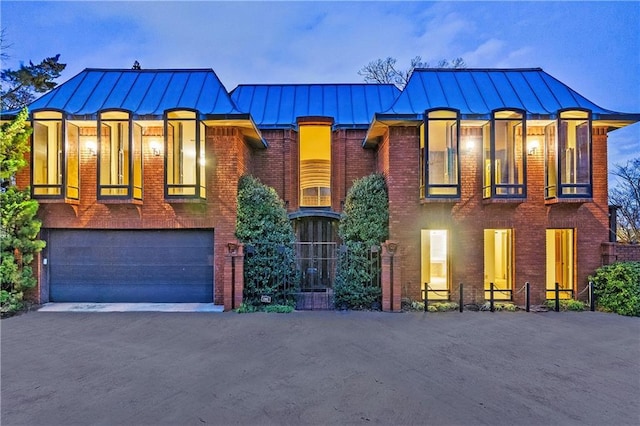 view of front of home featuring a standing seam roof, brick siding, and metal roof