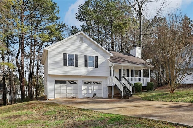 split level home featuring covered porch, a garage, concrete driveway, a chimney, and a front yard