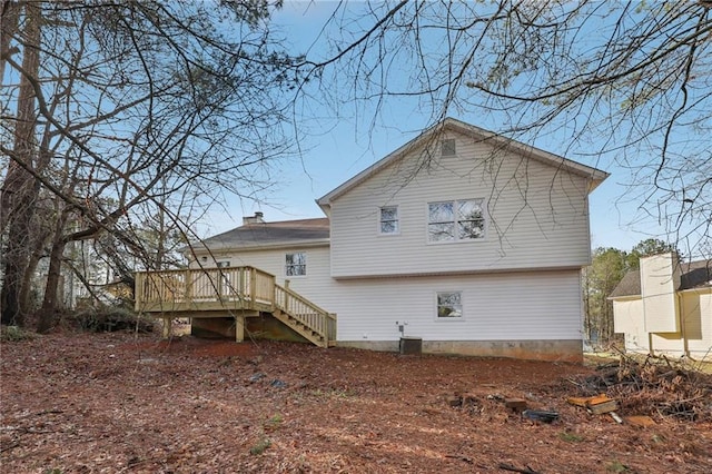 rear view of house featuring stairs and a wooden deck