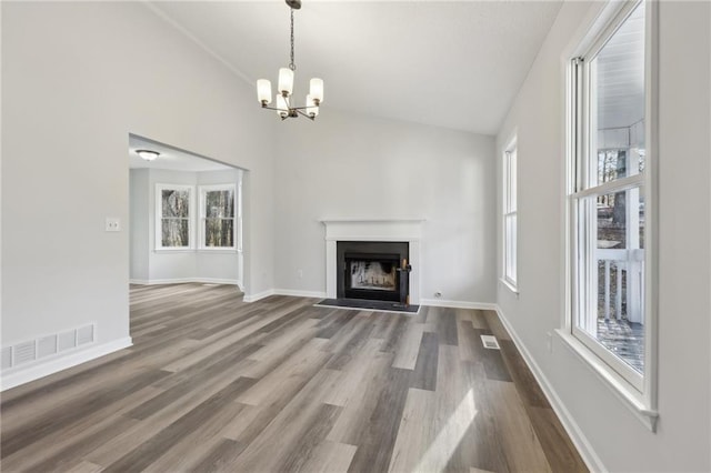 unfurnished living room featuring lofted ceiling, visible vents, a fireplace, and wood finished floors