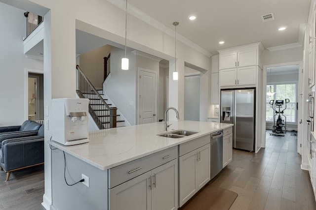 1459 Bennett Creek Ovlk, Suwanee, GA 30024 - kitchen with appliances with stainless steel finishes, ornamental molding, wood finished floors, hanging light fixtures, and white cabinetry