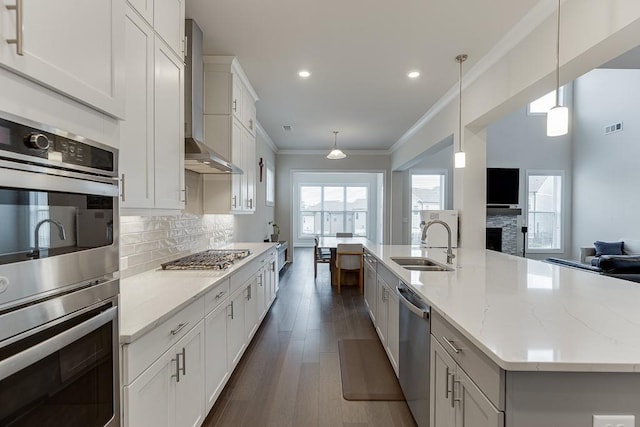 1459 Bennett Creek Ovlk, Suwanee, GA 30024 - kitchen featuring appliances with stainless steel finishes, wall chimney exhaust hood, open floor plan, decorative backsplash, and ornamental molding