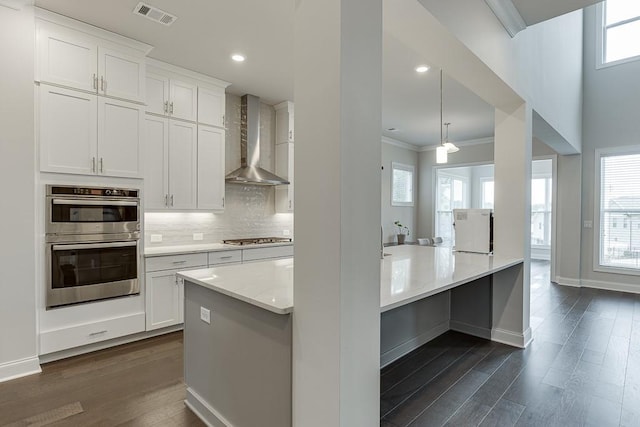 1459 Bennett Creek Ovlk, Suwanee, GA 30024 - kitchen featuring wall chimney exhaust hood, appliances with stainless steel finishes, ornamental molding, dark wood finished floors, and tasteful backsplash