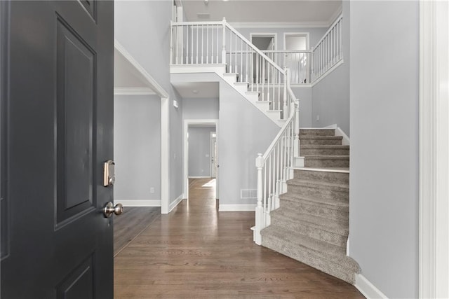 entrance foyer with a high ceiling, stairway, wood finished floors, and baseboards