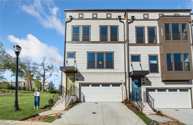 multi unit property with concrete driveway, a front lawn, and an attached garage