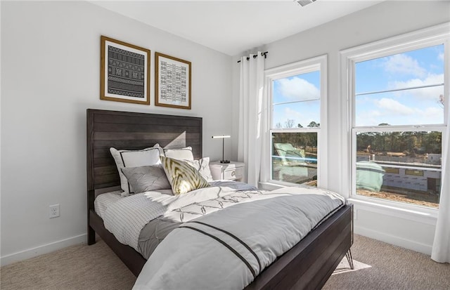 bedroom with light carpet and baseboards