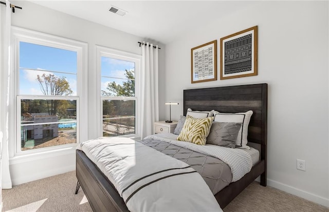 carpeted bedroom featuring visible vents and baseboards