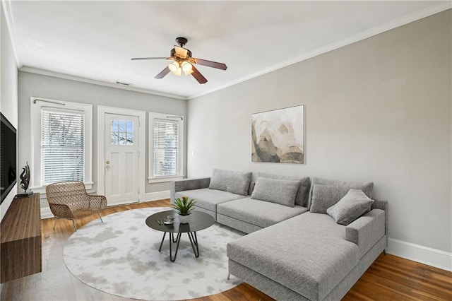 living room featuring visible vents, crown molding, baseboards, and wood finished floors