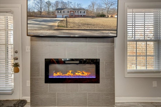 interior details with baseboards and a tile fireplace