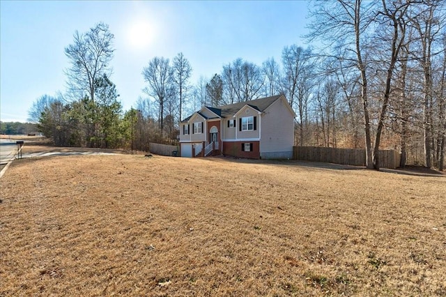 view of front facade featuring a front yard and fence