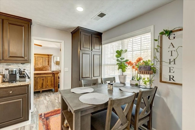 dining room featuring recessed lighting, visible vents, a textured ceiling, and light wood-style flooring