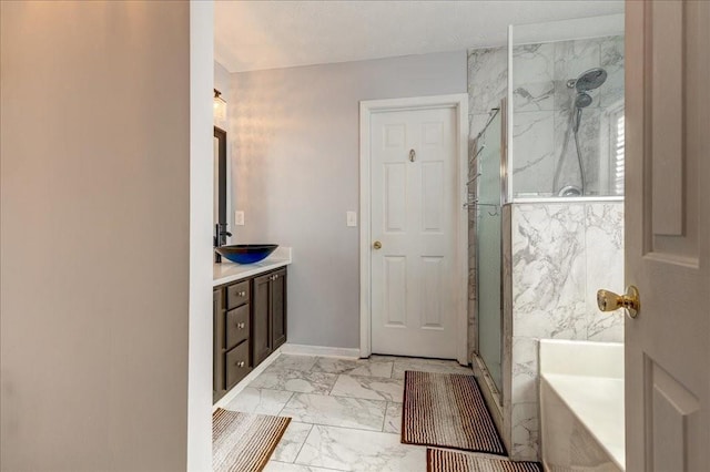 full bath featuring a garden tub, marble finish floor, a marble finish shower, baseboards, and vanity