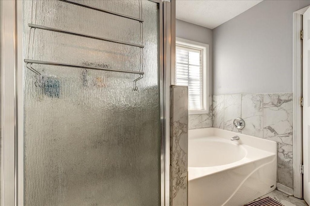 full bathroom with a shower stall and a garden tub