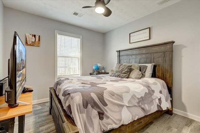 bedroom featuring wood finished floors, visible vents, and baseboards