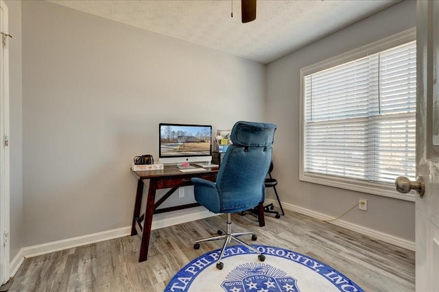 home office with baseboards, a textured ceiling, wood finished floors, and a ceiling fan