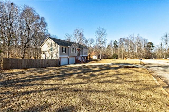 view of yard featuring an attached garage and fence