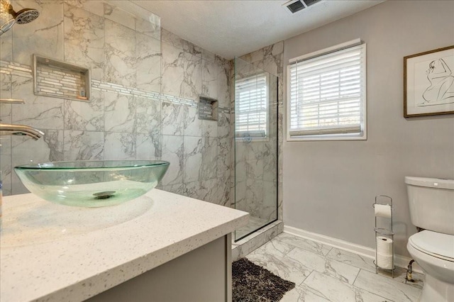 full bathroom featuring visible vents, toilet, marble finish floor, a textured ceiling, and a marble finish shower