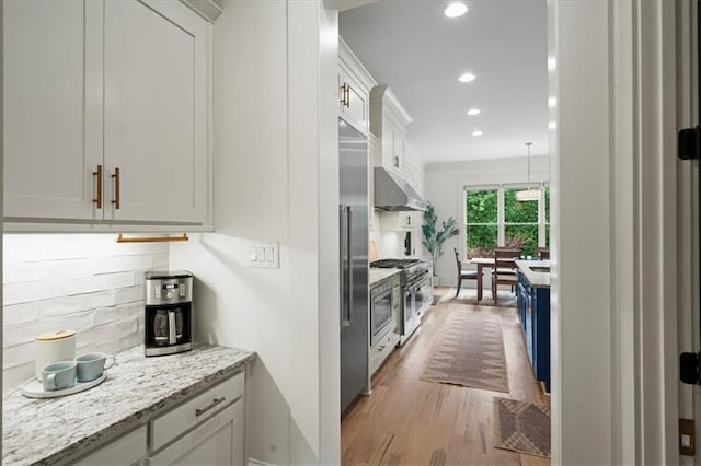 4048 Navajo Trl, Brookhaven, GA 30319 - kitchen featuring high end stove, under cabinet range hood, tasteful backsplash, wood finished floors, and recessed lighting