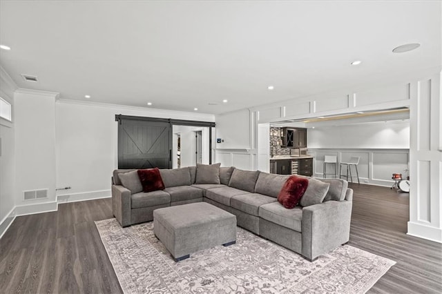 4048 Navajo Trl, Brookhaven, GA 30319 - living area featuring a barn door, a decorative wall, crown molding, dark wood-style floors, and recessed lighting