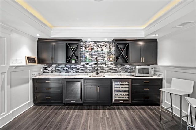 4048 Navajo Trl, Brookhaven, GA 30319 - bar area featuring wine cooler, a raised ceiling, a sink, dark wood-style floors, and a decorative wall