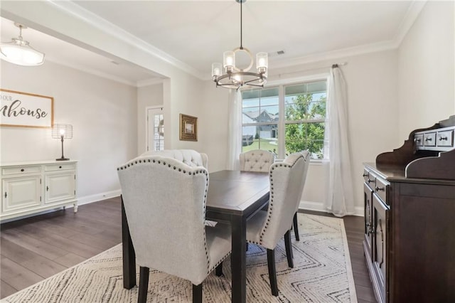 dining room featuring dark wood-type flooring, a notable chandelier, crown molding, and baseboards