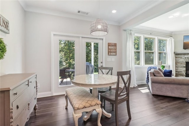 dining space featuring baseboards, visible vents, dark wood-style flooring, and crown molding